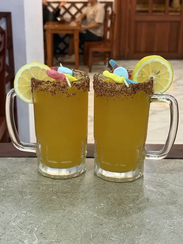 Dos micheladas de maracuyá con borde de chile y gomitas